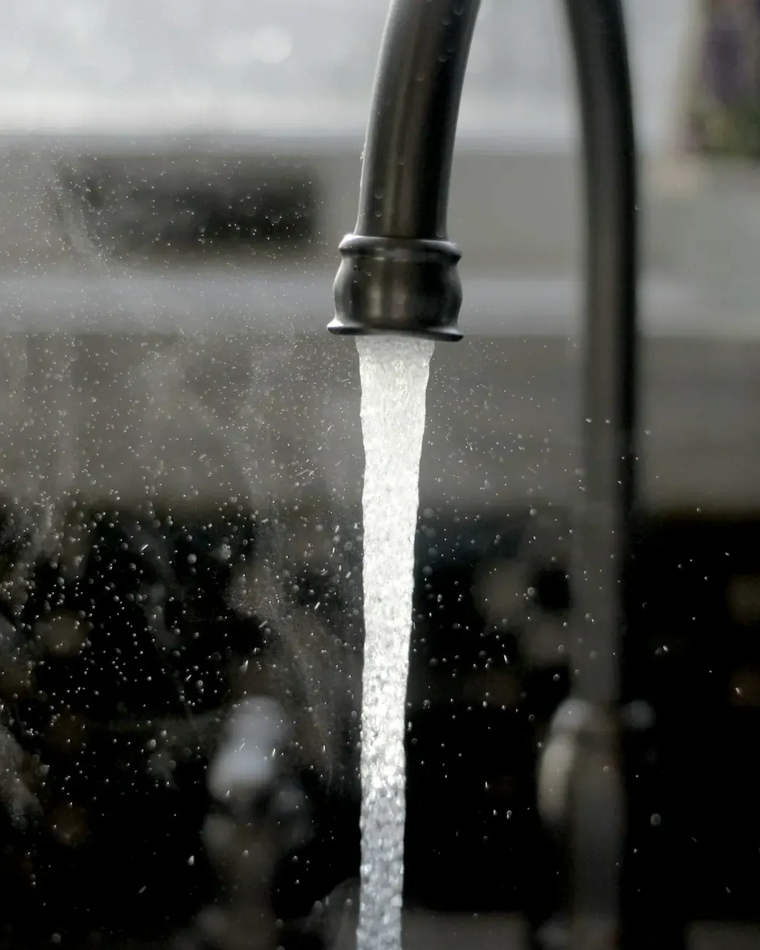 Water pouring from a black kitchen faucet