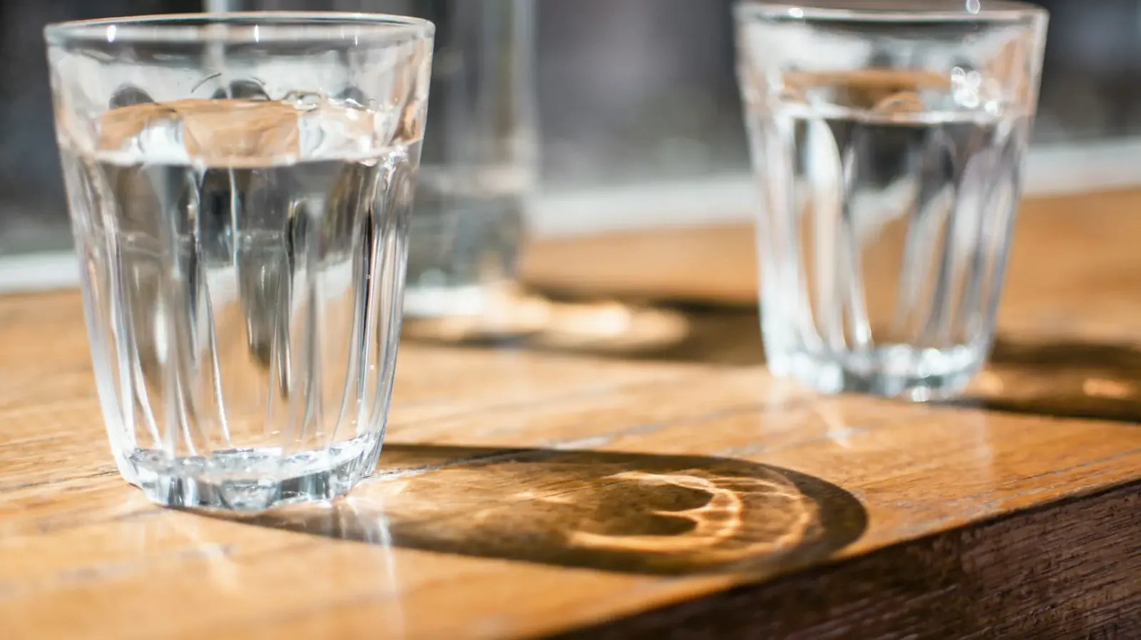 Glass of clear water on a wooden table
