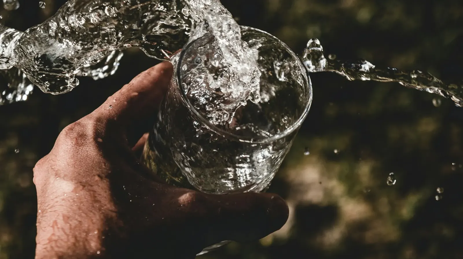 Clear water splashing as a glass is filled
