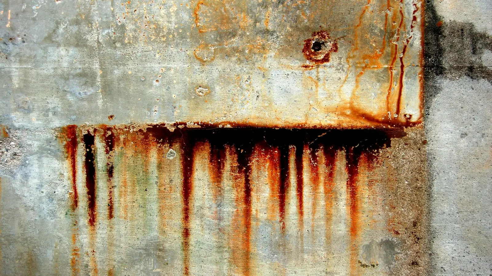 Orange rust stains streaking down a wall