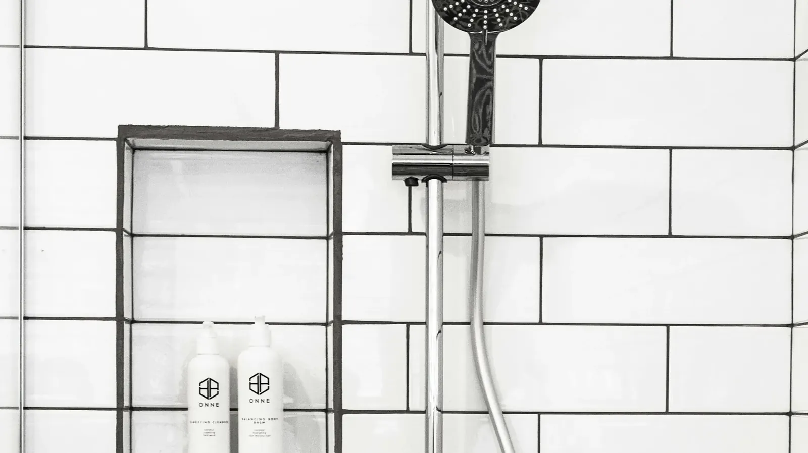 Shower head on a white tiled wall