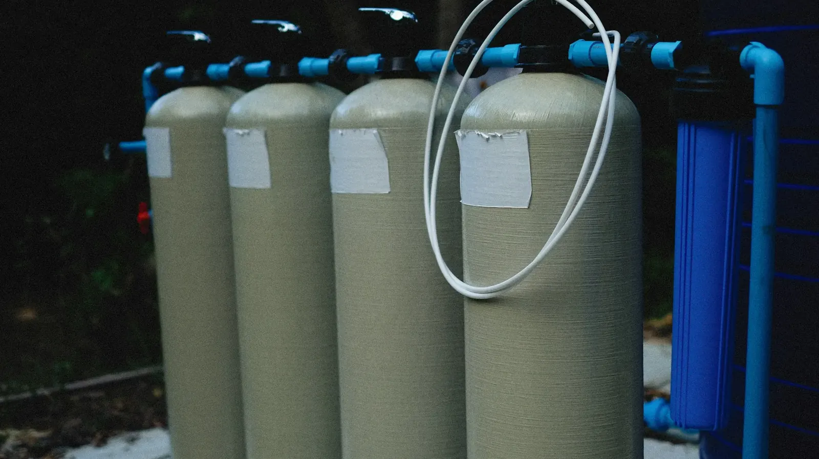 Two water softener tanks connected with blue pipe